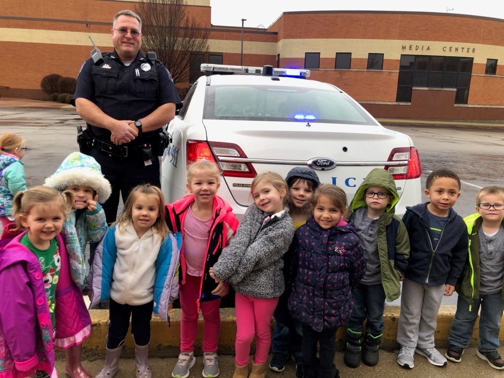 officer and little kids in front of police car